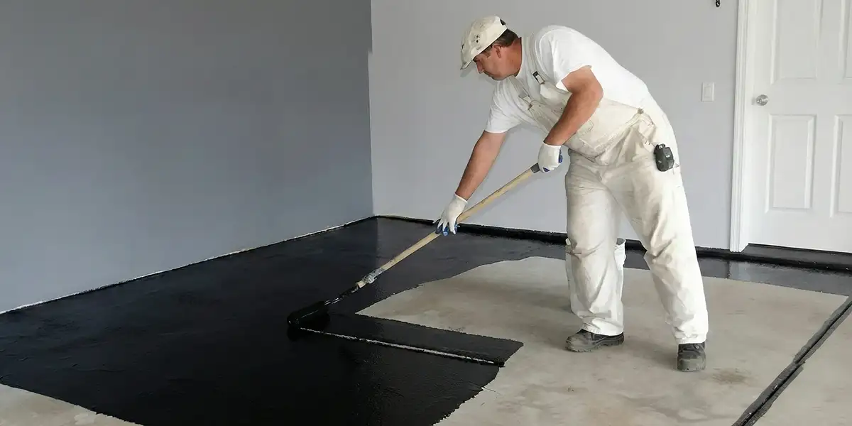 basement waterproofing professional applying waterproof coating to protect a basement floor in Omaha, NE